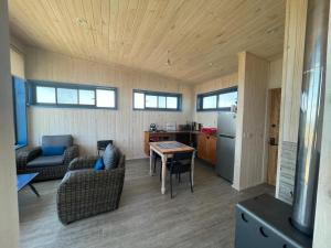 een woonkamer met een tafel en een keuken bij Cabaña para 2 con jacuzzi campo mar in Matanzas