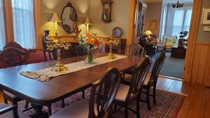 a dining room table with a vase of flowers on it at The Lark & Loon Inn in Annapolis Royal