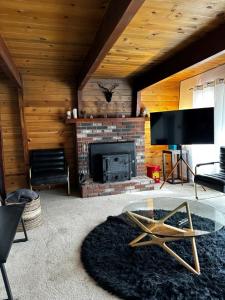 a living room with a fireplace and a glass table at Cozy Crescent Tree Cabin Near Bear Mountain in Big Bear Lake