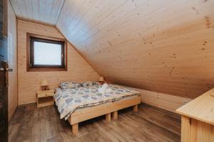 a bedroom with a bed in a wooden cabin at Gazdov dvor in Dolný Kubín