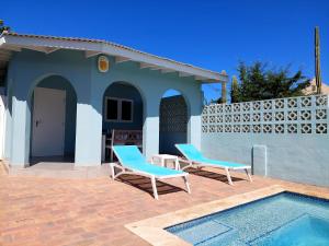 duas cadeiras e uma piscina em frente a uma casa em Apartment Villa Valentina em Noord