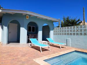 two chairs and a swimming pool in front of a house at Apartment Villa Valentina in Noord