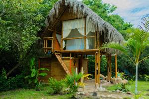 a small house with a thatched roof at Glamping 8Caminos in Carmen de Apicalá