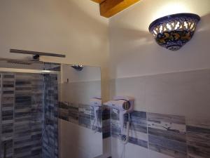 a bathroom with a shower and a chandelier on the wall at Camera Nta Cantunera in San Biagio