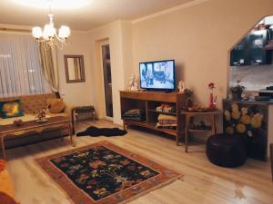 - un salon avec un canapé et une télévision dans l'établissement Apartamentai, à Tauragė