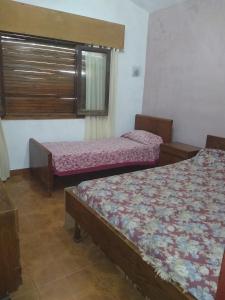 a room with two beds and a window at Chalet los Abuelos in La Falda