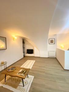 a living room with white walls and a table at L'AGACHON LA CIOTAT VIEUX PORT in La Ciotat