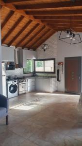 eine große Küche mit weißen Geräten und einer Holzdecke in der Unterkunft Cabañas LOS BEDUINOS in Mar de las Pampas + 126 Fotos