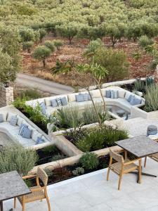 a garden with couches and tables and trees at Panorama Apartments updated with infinity pool in Agios Nikolaos