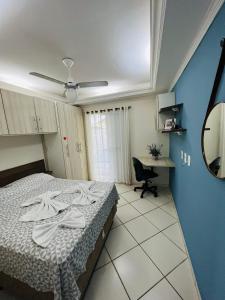 a hotel room with a bed and a desk at LOFT NOVO CONFORTÁVEL in Sorocaba