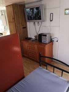 um quarto com uma televisão numa cómoda e uma cama em Baza Turystyczna Atol em Władysławowo