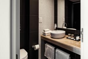 a bathroom with a sink and a toilet at be.HOTEL in St. Julianʼs