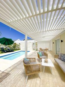 a white pergola over a patio with a pool at Xeliter Green One Playa Dorada in San Felipe de Puerto Plata +291 photos