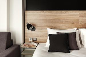 a bedroom with a bed with a wooden headboard at be.HOTEL in St. Julianʼs