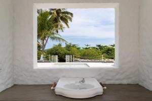 baño con lavabo y ventana con vistas. en Lilota da Barra - Charme e alto padrão, en Barra de São Miguel