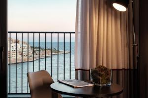 a room with a table and a view of the ocean at be.HOTEL in St. Julianʼs