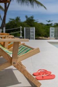un sillón con un par de chanclas rojas en Lilota da Barra - Charme e alto padrão, en Barra de São Miguel