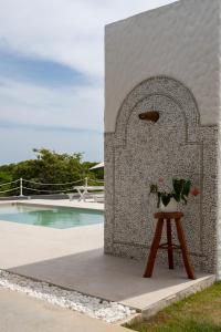 una mesa con flores junto a una piscina en Lilota da Barra - Charme e alto padrão, en Barra de São Miguel