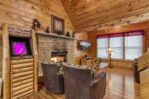 a living room with a fireplace in a log cabin at Point Of View - Spacious 2 Bedroom With a Loft Just off Glades Road cabin in Gatlinburg