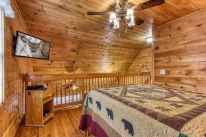 a bedroom with a bed in a room with wooden walls at Point Of View - Spacious 2 Bedroom With a Loft Just off Glades Road cabin in Gatlinburg