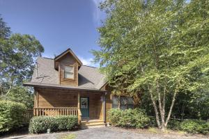 a wooden house with a porch and a tree at Point Of View - Spacious 2 Bedroom With a Loft Just off Glades Road cabin in Gatlinburg