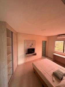 a bedroom with a bed and a tv in it at Hotel Pousada Posto Carvalho in Campo Formoso