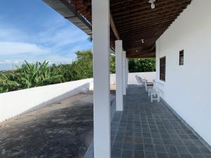 a porch of a house with white walls and chairs at Casa do Vale in Triunfo