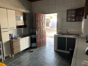 uma cozinha com uma porta aberta para uma cozinha com um lavatório em Casa do Vale em Triunfo
