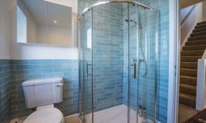 a bathroom with a toilet and a glass shower at La Mouette in Brixham +42 photos