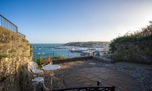a patio with a table and chairs and the ocean at La Mouette in Brixham