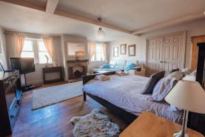 a bedroom with a large bed and a tv at The Vestry - Chapel Retreat With Hot Tub in Haworth