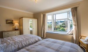 a bedroom with a bed and a window at La Mouette in Brixham