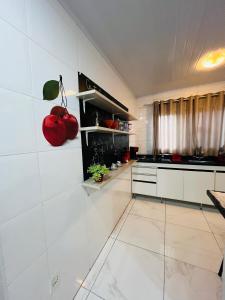 a white kitchen with a red apple on the wall at Casa do Henrique 2 in Sorocaba