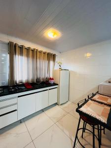 a kitchen with a refrigerator and a table in it at Casa do Henrique 2 in Sorocaba