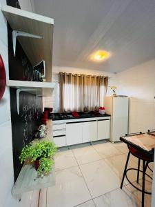 a kitchen with white cabinets and a stove top oven at Casa do Henrique 2 in Sorocaba