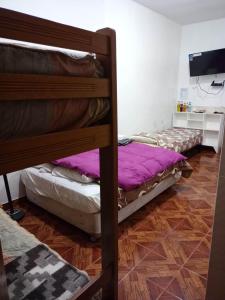 a bedroom with two bunk beds and a television at Hospedaje Del Pilar en Magdalena del Mar in Lima