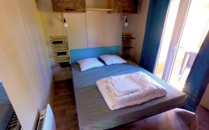 a small bedroom with a bed with two pillows at Glamping Terre & Mer in Étables-sur-Mer +73 photos