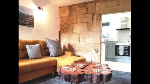 een woonkamer met een bank en een houten tafel bij Coiners Rest in Heptonstall