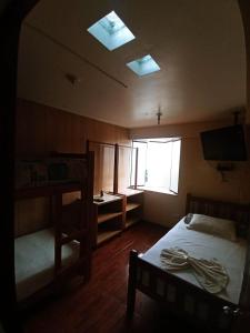 1 dormitorio con cama, ventana y TV en Hospedaje Del Pilar en Magdalena del Mar en Lima