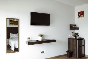 1 dormitorio con TV en una pared blanca en Quintas Marlet en la ruta del vino, en Ensenada