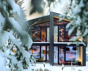 una casa en la nieve con puertas de cristal en KOKON Apartments, en Leutasch