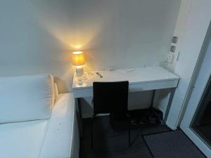Habitación con escritorio, cama y lámpara. en ÖLJERSJÖ COTTAGE en Lyckeby