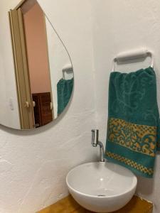 a bathroom with a sink and a mirror at Caju com Mel in Moreré