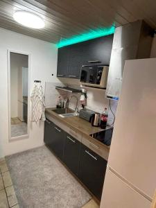uma pequena cozinha com um lavatório e um frigorífico em ÖLJERSJÖ COTTAGE em Lyckeby