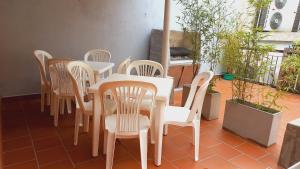 una mesa blanca y sillas en un patio en HABITACIONES en casa palermo con terraza y parrilla en Buenos Aires