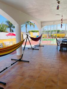 um quarto com uma rede de descanso, uma mesa e cadeiras em Villa Guadalupe em Moncófar