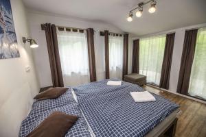 a bedroom with a large bed with two towels on it at Chata Orlik - all inclusive & wellness in Pec pod Sněžkou