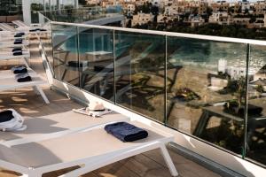 a balcony with white benches and a view of a city at be.HOTEL in St. Julianʼs
