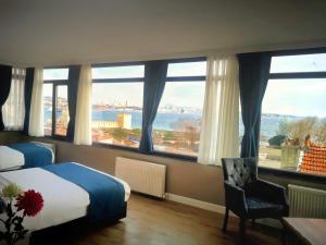 Habitación de hotel con cama y ventanas grandes. en Cape Palace Hotel en Estambul