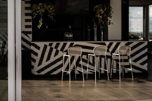 a group of four chairs sitting at a bar at be.HOTEL in St. Julianʼs